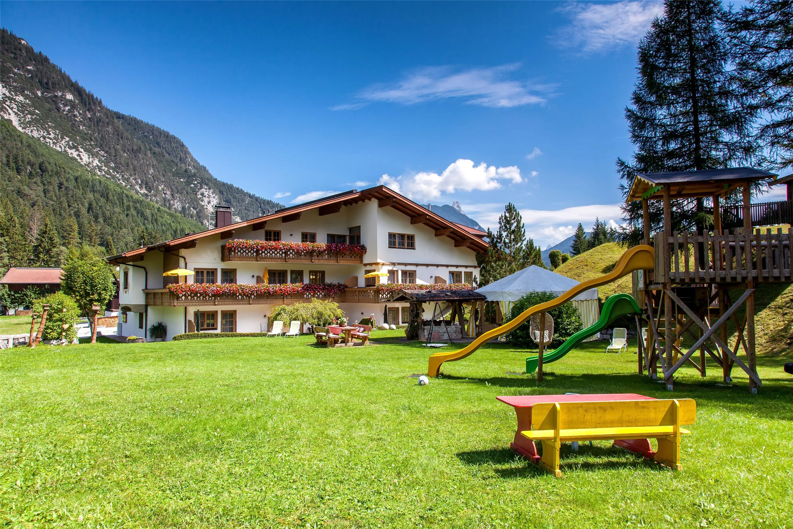 Ferienhaus Kirchplatzl in Leutasch mit Garten und Bergen im Hintergrund
