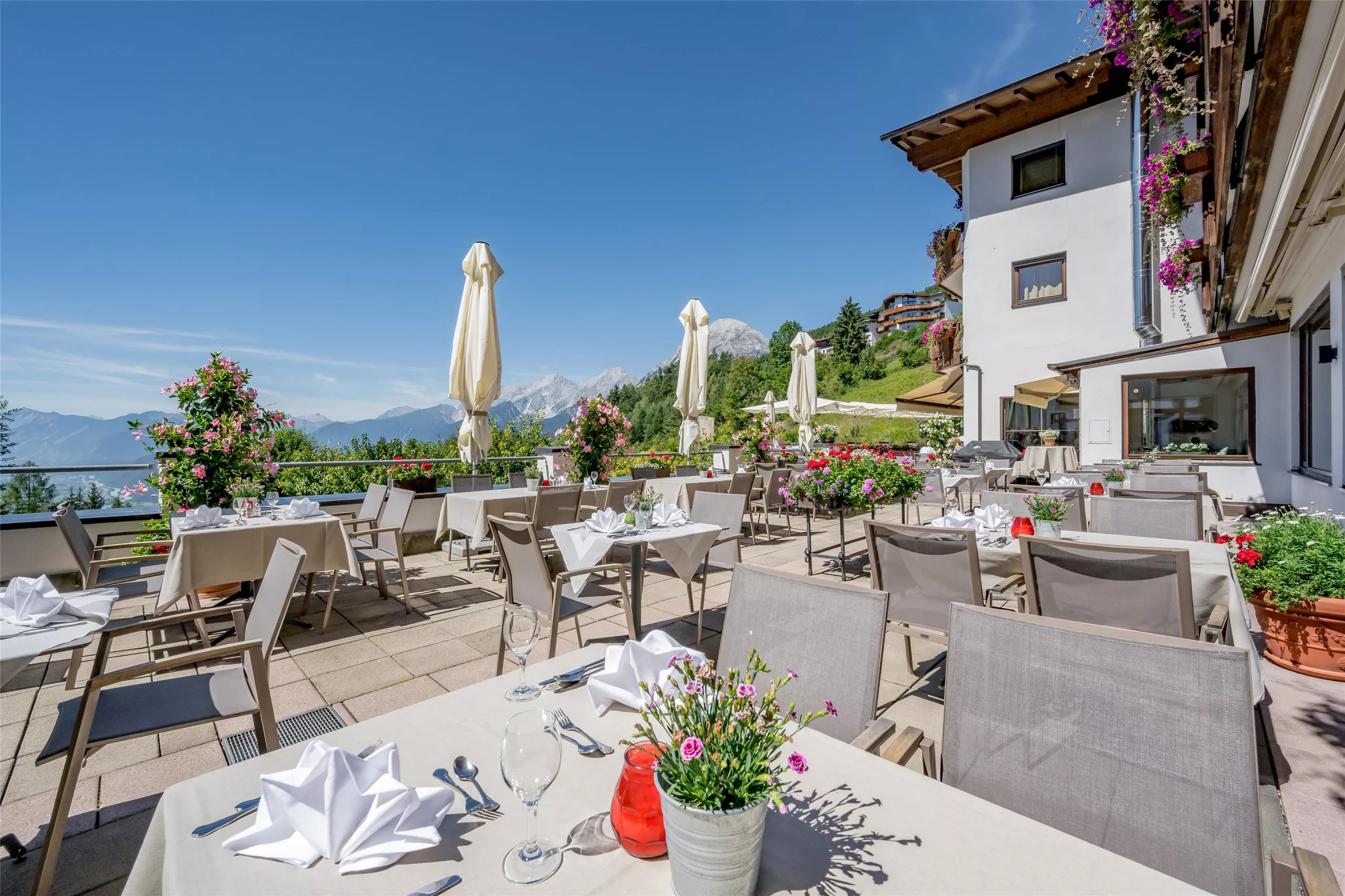 Terrasse des Inntalerhofs in Mösern mit Tischen und Blick auf die Berge