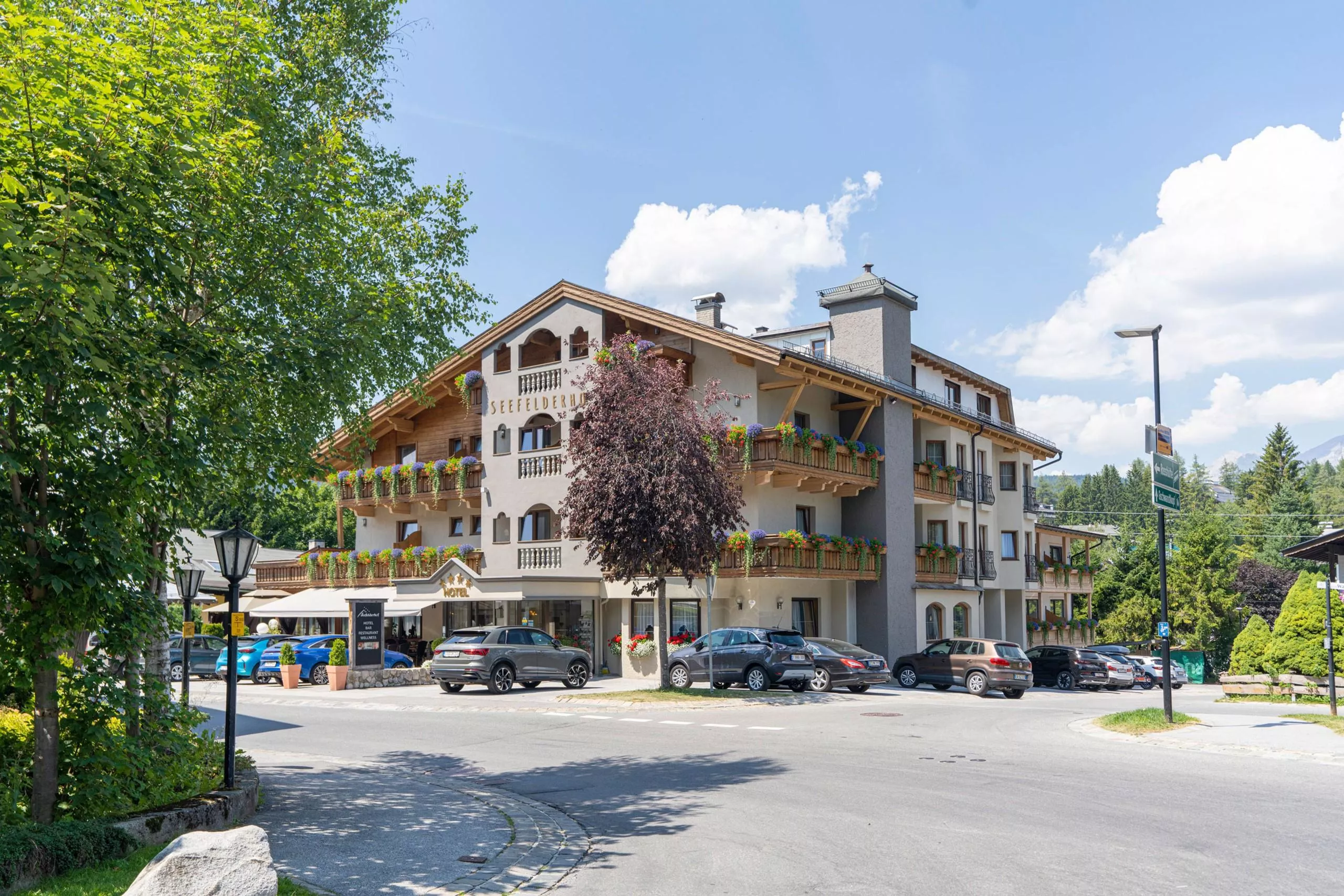 Hotel Seefelderhof in Seefeld mit Balkonen, Blumenschmuck und Bäumen