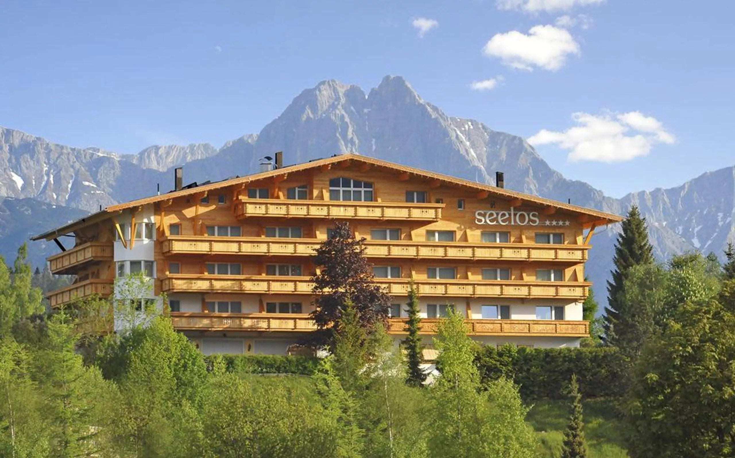 Hotel Seelos in Seefeld vor bewaldeten Hängen und Felsbergen