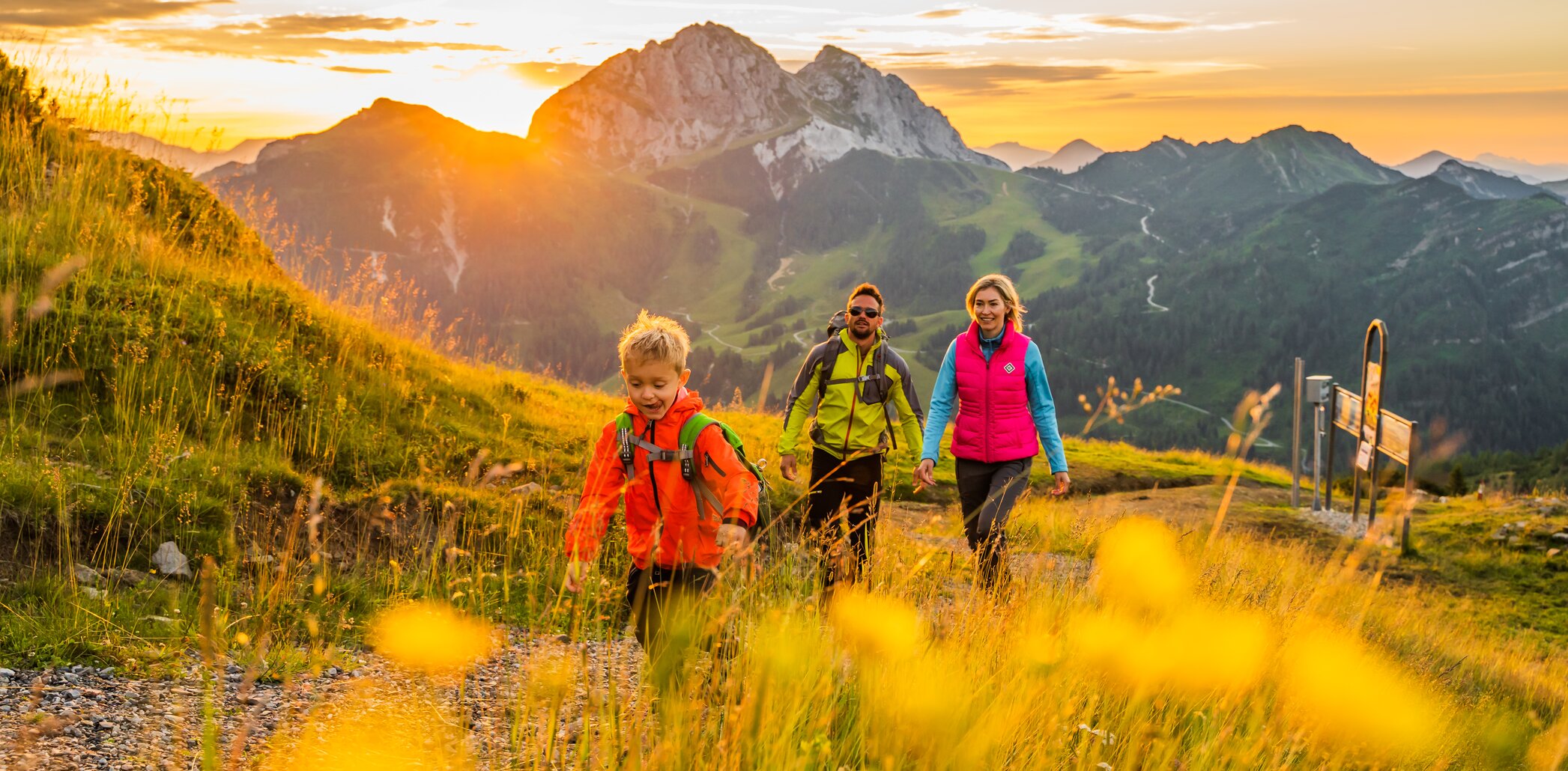 Drei Wandernde im Morgenlicht auf der Madritsche am Nassfeld