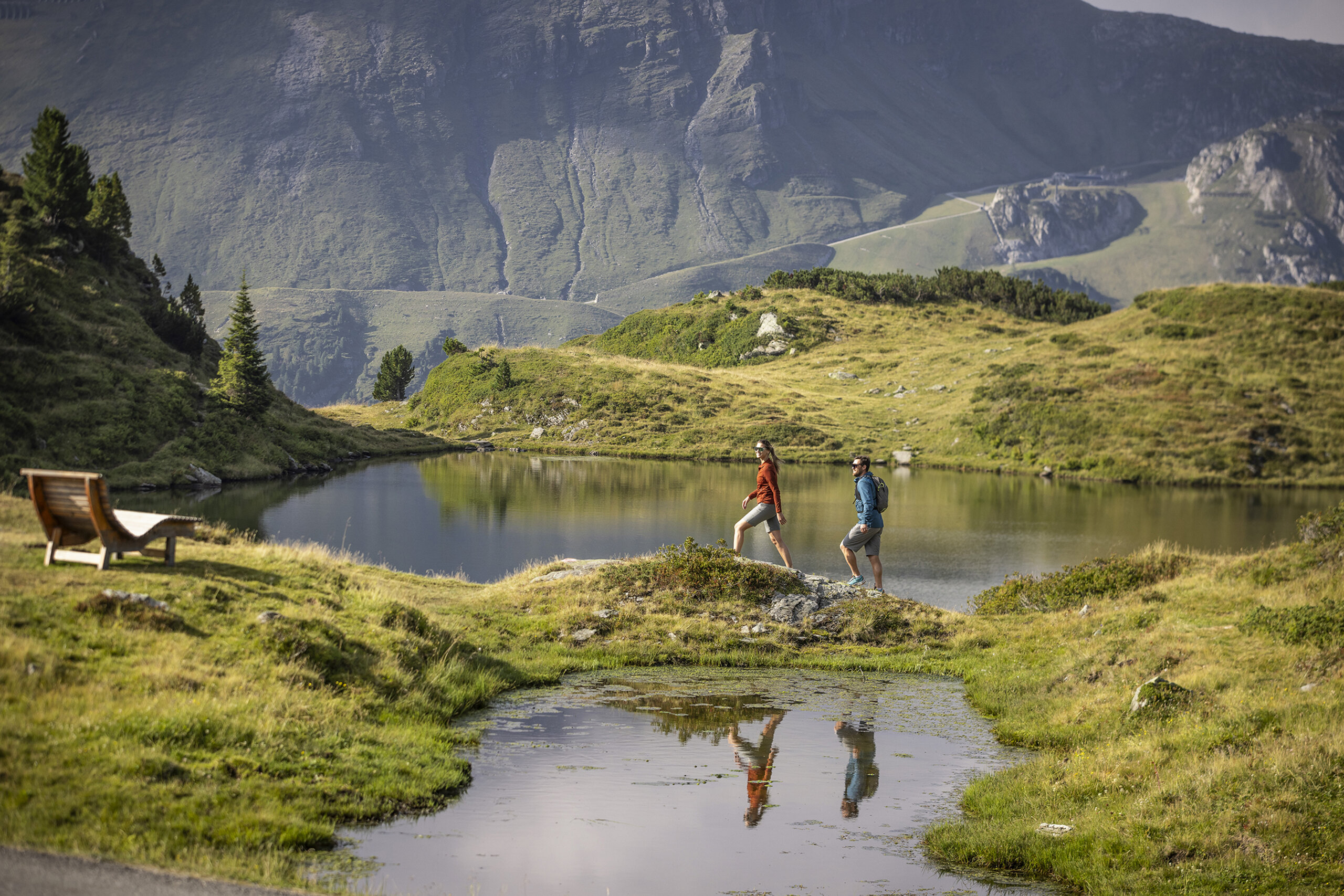 Wandernde an kleinen Bergseen zwischen grünen Hängen in Obertauern