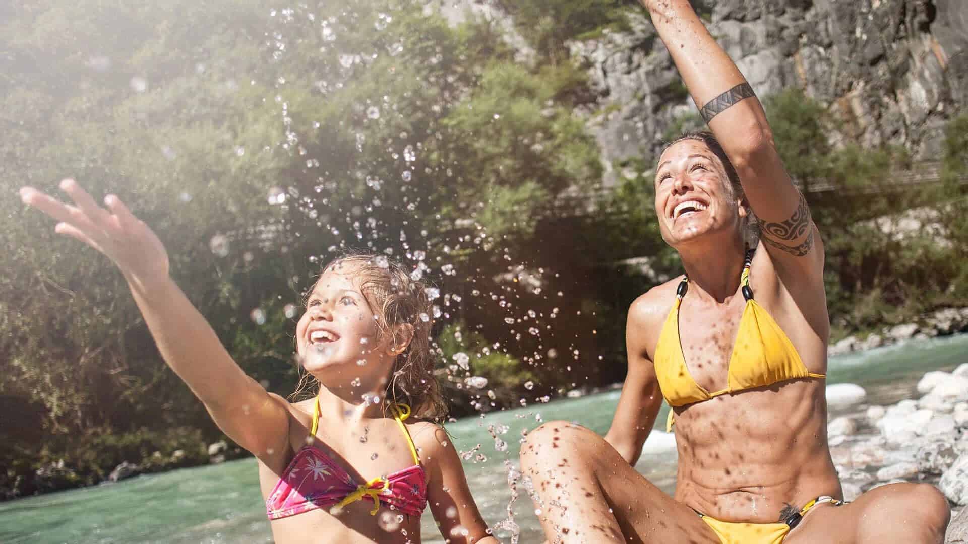 Zwei Kinder spielen mit Wasser im Salzburger Saalachtal